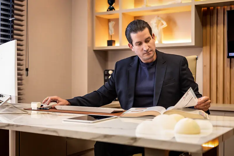Dr. Felipe Seixas lendo à mesa do consultório