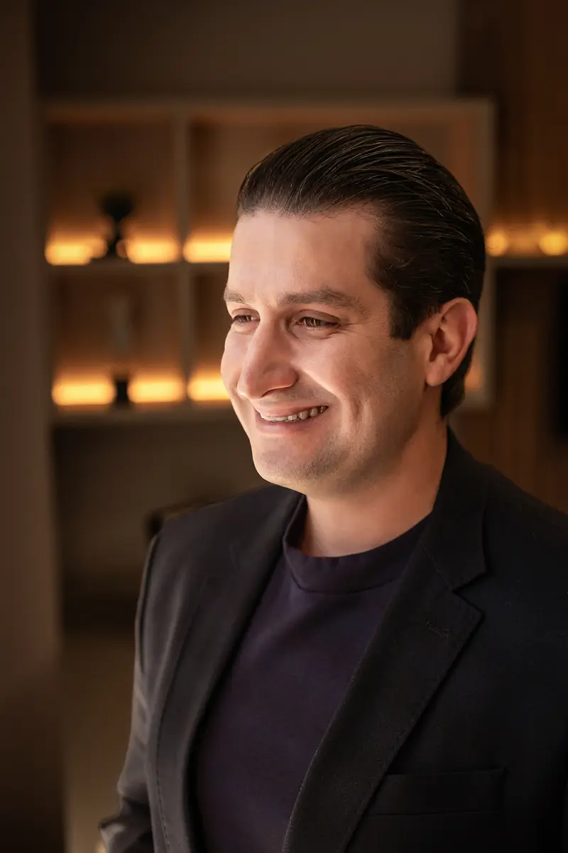 Dr. Felipe Seixas sorrindo, em retrato fechado no consultório
