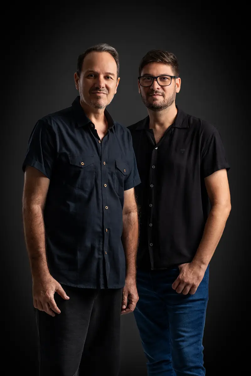 Flávio e Fábio Anoni em retrato de estúdio com fundo escuro